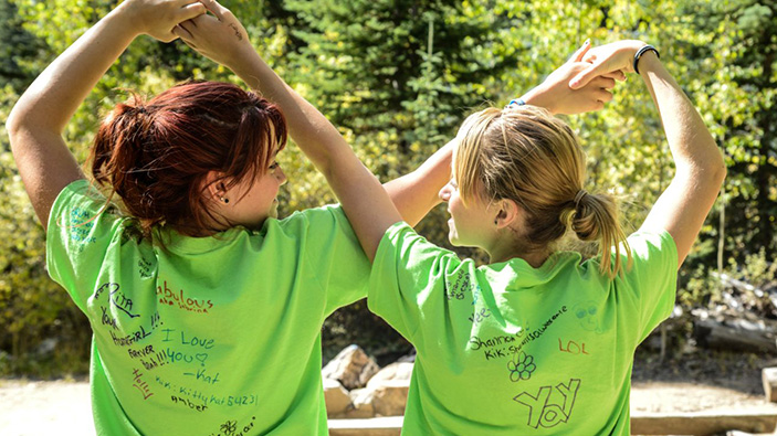 Two young girls hold heads in the air