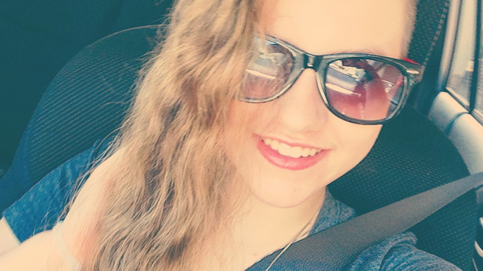 selfie of a young women smiling wearing sunglasses