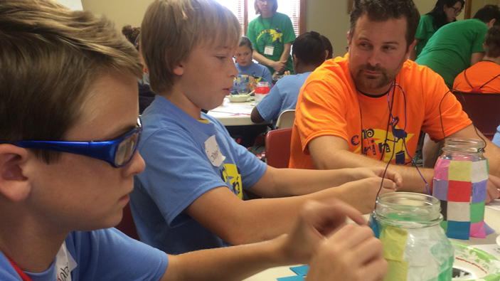 Kids and counselor doing crafts at a table