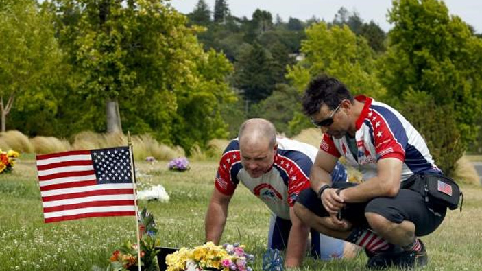 Two people honoring a grave site