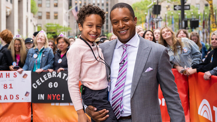 Craig Melvin from NBC's today show holding his child on set