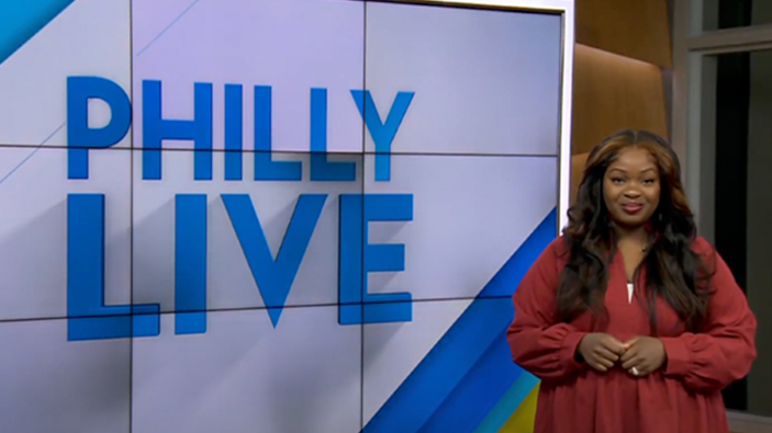 Female reporter standing in front of Philly Live television