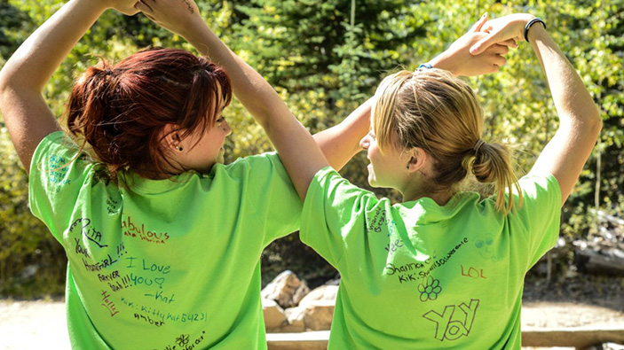 two women with their backs to the camera where green shirts