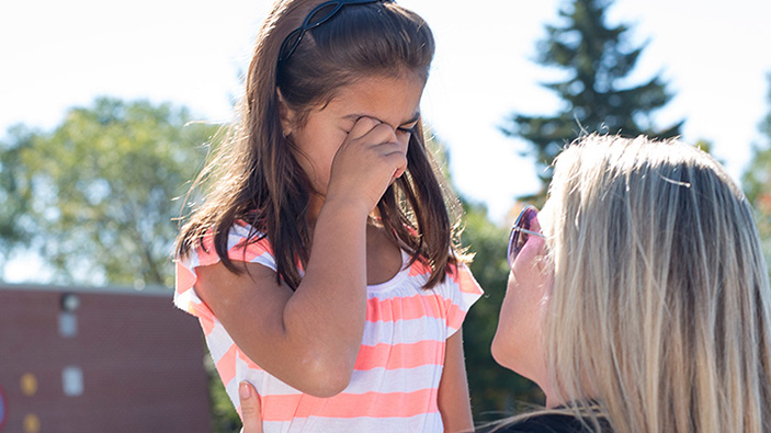 Adult woman consoling a little who's crying