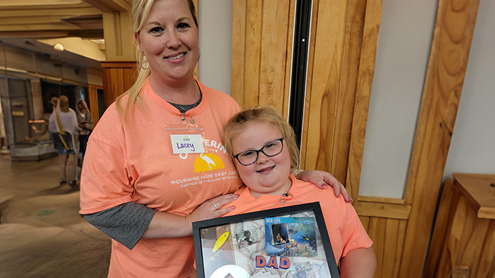 Mom and daughter posing with a scrapbook picture