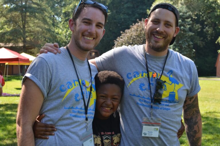 Two counselors supporting a camper at an Eluna Camp