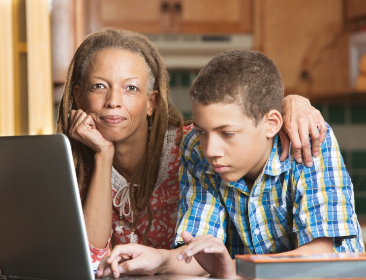 a mother helping her son with his homework.