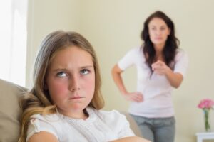 an angry child rolling her eyes while mom is telling her something.