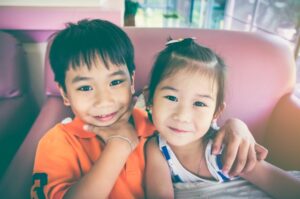 two siblings hugging and smiling