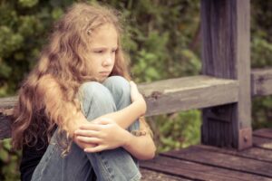 an upset child sitting alone