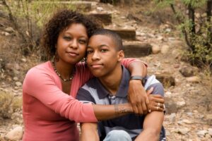 a mother hugs her high school aged child