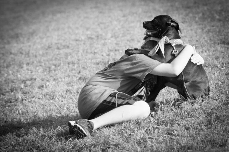 a middle school aged child hugs her dog