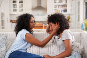 a mother consoles her daughter