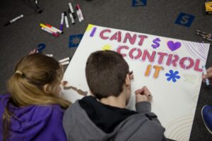 Camp Mariposa campers working on a poster activity together.