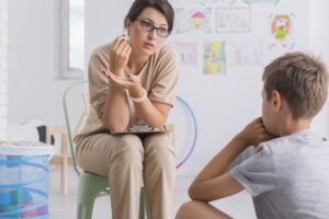 a teacher talking to a boy in class