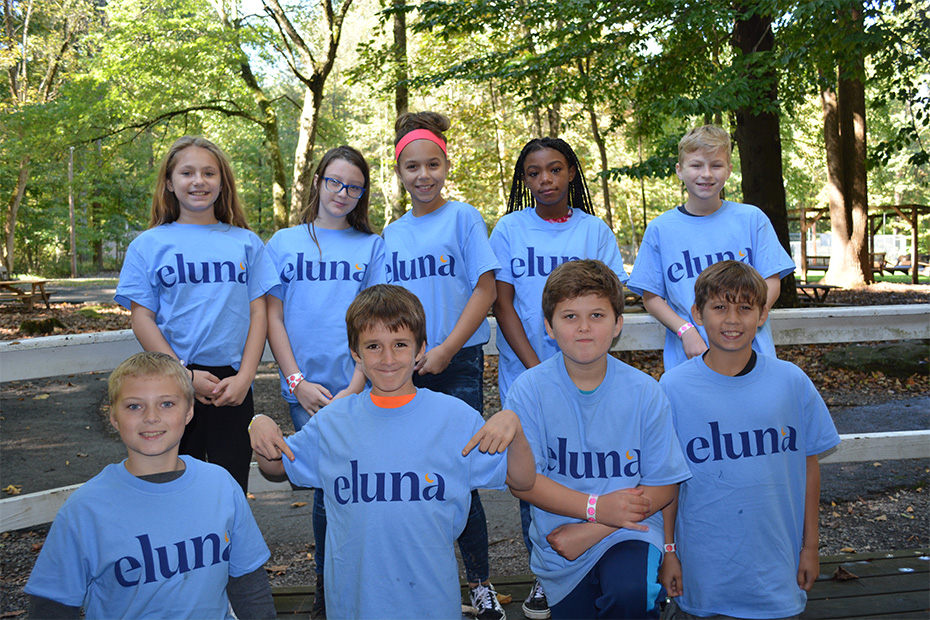 Group of kids in Eluna t-shirts smiling at the camea