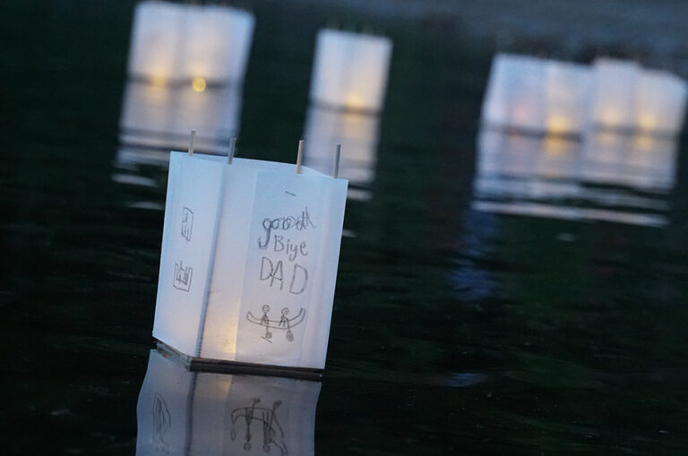 Tea light bag floating in water with goodbye message to a dad.