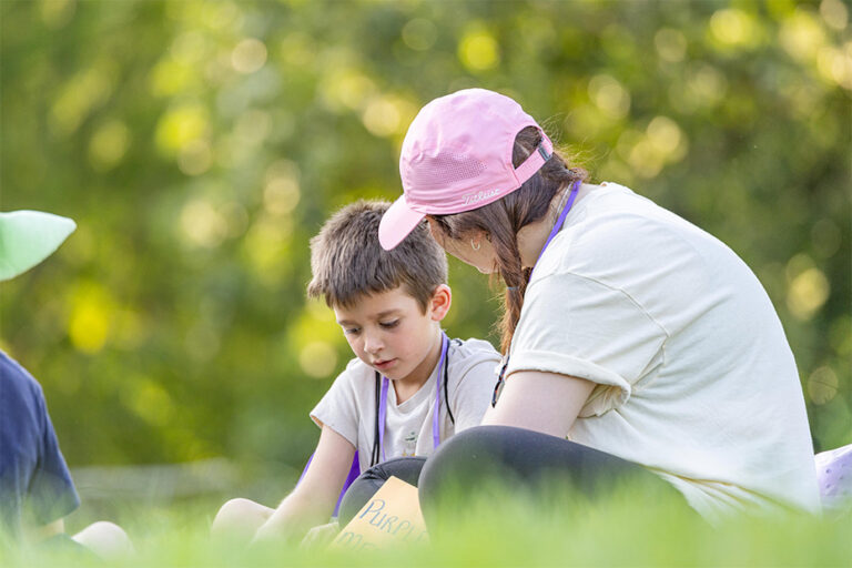 Adult and child sitting in the grass